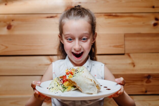 Amazed  little girl with vegetarian Wrap iceberg