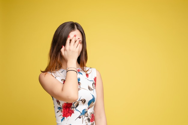 Amazed lovely woman covering face with hand