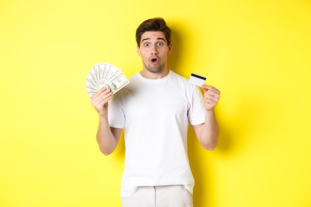 Amazed man holding credit card and money