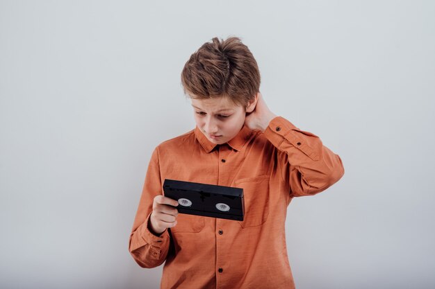 Amazed preteen with video tape isolated on white background