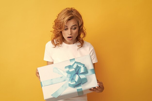 Photo amazed redhead girl with gift box boxing day