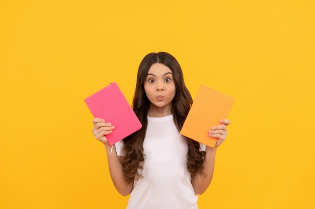 Amazed school kid ready to study choose notebook knowledge