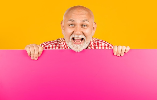 Photo amazed senior man with copy space on blank banner advertising