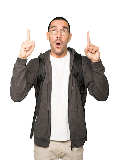 Amazed student pointing up with his finger