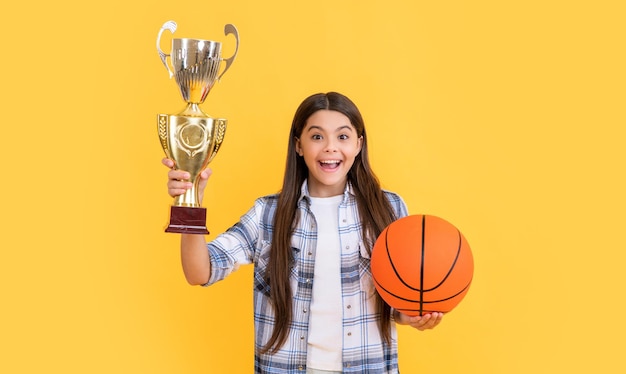 Amazed teen champion girl on background photo of teen champion girl with basketball ball