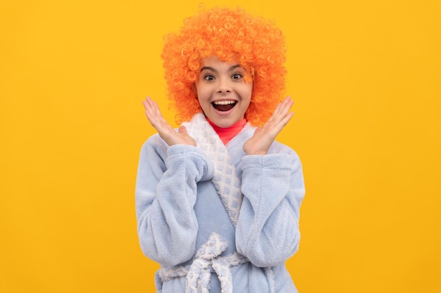 Amazed teen girl in fancy orange wig hair wear home bathrobe amazement