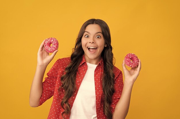 Amazed teen girl hold sweet baked doughnut dessert diet