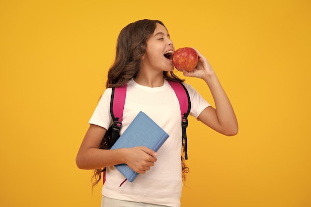 Amazed teen girl schoolgirl in school uniform hold apple school and education concept back to school schoolchild teenage student studying excited expression cheerful and glad