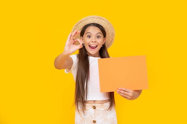 Amazed teen kid with copy space on orange paper on yellow background