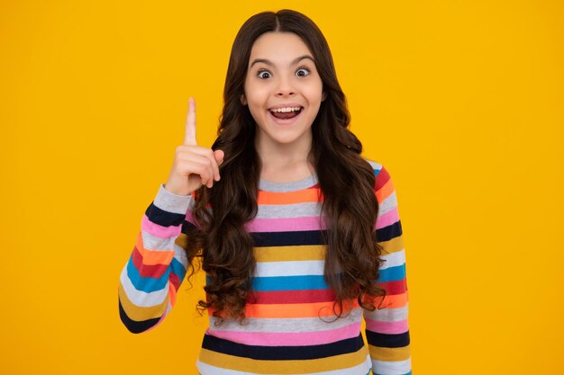 Amazed teenager excited teenager girl opening mouth in excitement believe big sale or promo on yellow studio background copy space excited teen girl