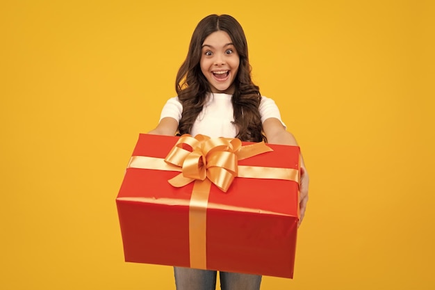 Amazed teenager portrait of teenager child girl 12 13 14 years old holding christmas gift box teen giving birthday gift excited teen girl