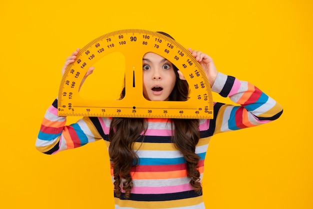Amazed teenager Teenager child school girl holding measure for geometry lesson Measuring height