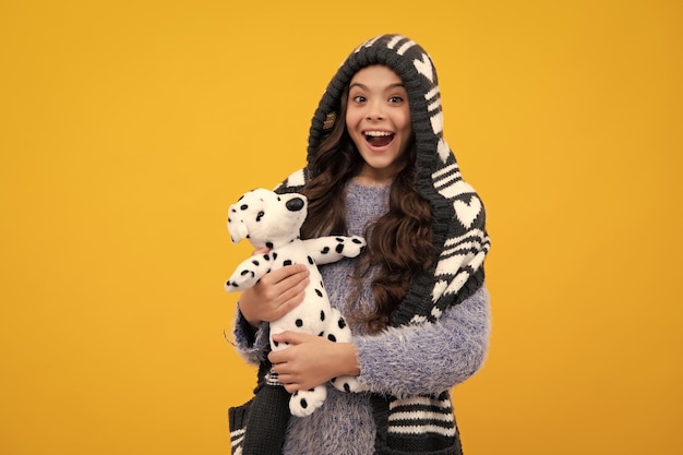 Premium Photo | Amazed teenager Teenager girl 12 13 14 year old hold soft toy for birthday on yellow background Kid with her toys Autumn or winter kids wear Excited teen girl