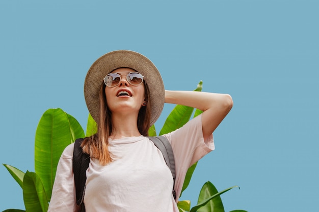 Amazed woman near tropical plant looking away