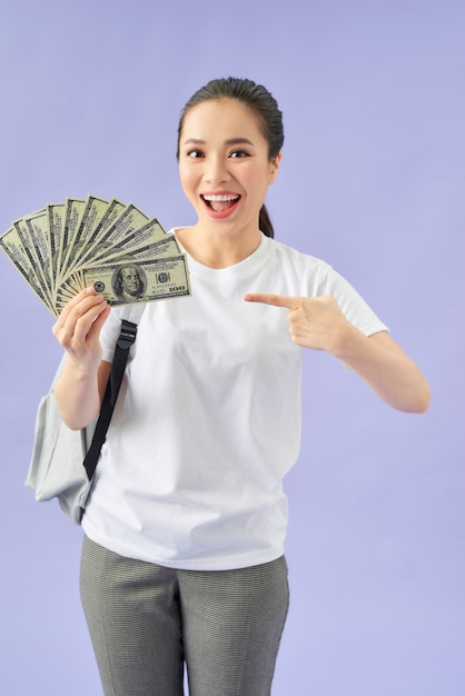 Amazed woman student hold fan of cash money in dollar banknotes doing winner gesture