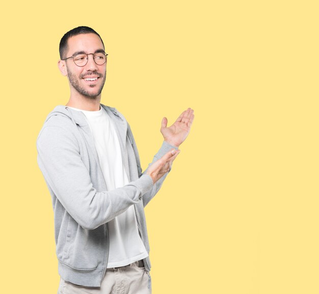 Amazed young man making a gesture of welcome