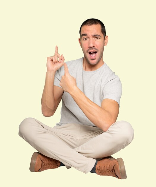 Amazed young man making a gesture of welcome