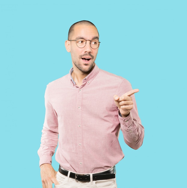 Amazed young man pointing at you with his finger