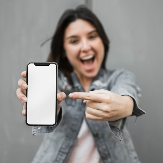 Photo amazed young woman showing smartphone