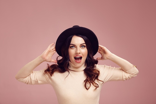 Amazement adult girl expresses surprised and mouth wide open standing over pink background