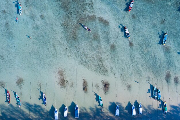 Photo amazing aerial top view longtail fishing boats in the tropical sea at rawai beach phuket thailand