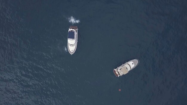 Photo amazing aerial top view of two yachts and swimming friends in dark blue water clip people having fun