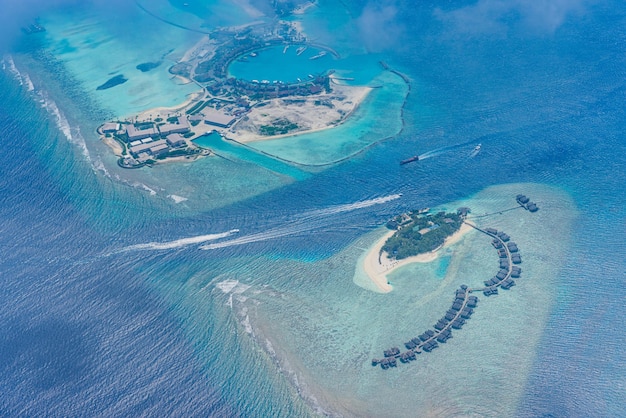 Amazing atoll islands in Maldives aerial view. Tranquil tropical landscape seascape villas boats