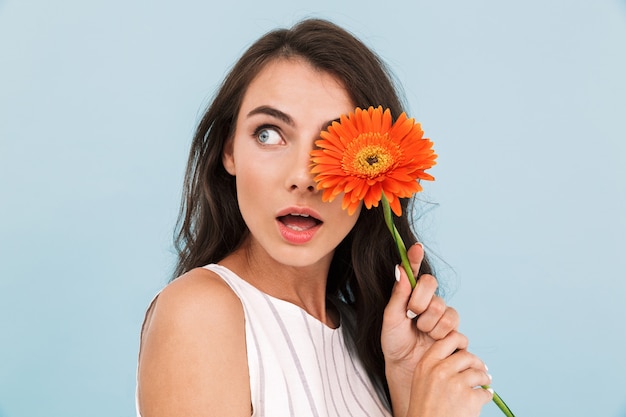 Photo amazing beautiful young woman isolated wall holding flower.