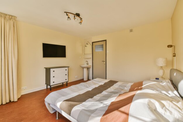 Amazing bedroom with striped bedspread on the bed and orange floor