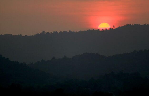 Amazing bright sunset over the silhouette of mountain ranges