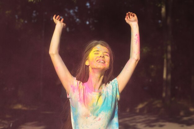 Photo amazing  brunette woman posing with holi powder exploding around her