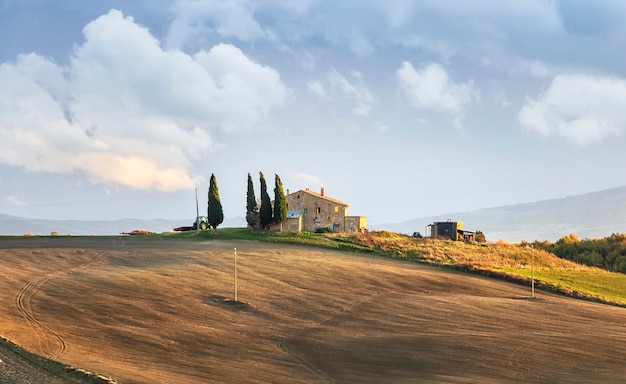 Amazing clouds, small farm house and alley of cypress trees before the storm. Val d'Orcia. Italian countryside. Tuscany. Italy. Europe