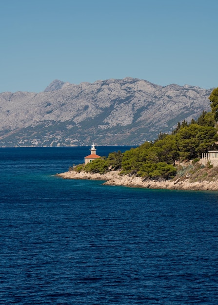 Amazing coast Mountains covered with greenery Blue sea Lonely lighthouse Croatia Makarska