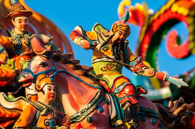 Удивительная красочная фигурка китайского воина на коне, сосредоточенная с копьем в руках.