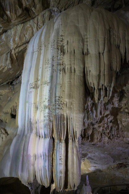 Foto incredibile cascata di pietra colorata nella grotta di new athos in abkhazia