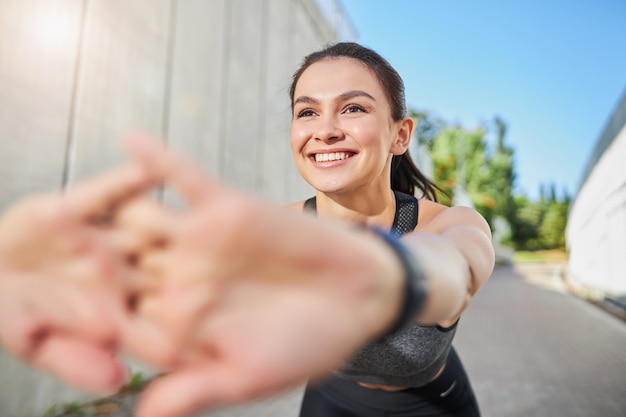 Incredibile persona di sesso femminile che mantiene il sorriso sul viso mentre fa sport con grande piacere