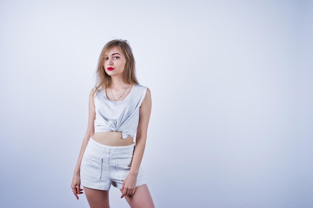 Amazing fit sexy body brunette caucasian girl posing at studio against white background on shorts and top