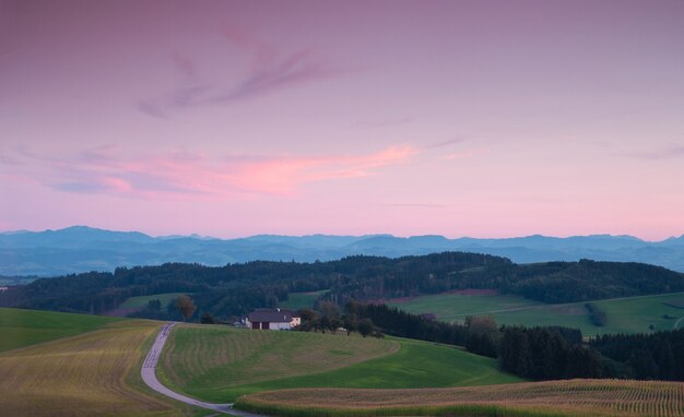 Incredibile paesaggio di colline verdi sul tramonto rosa.