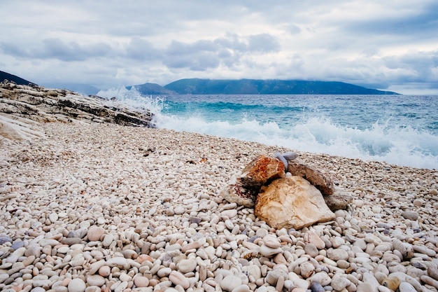 Incredibile paesaggio di ciottoli sulla spiaggia al mare blu