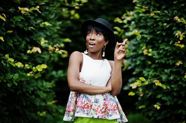 Amazing model woman in green pants and black hat posed with different emotions at park