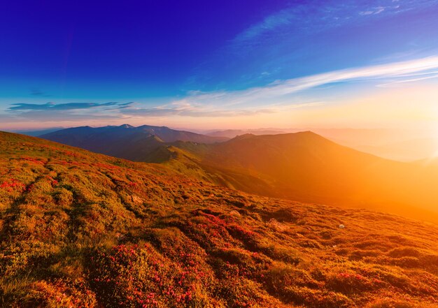 青い空、自然な屋外旅行の背景にカラフルな鮮やかな日の出と素晴らしい山の風景。美容の世界。全景。