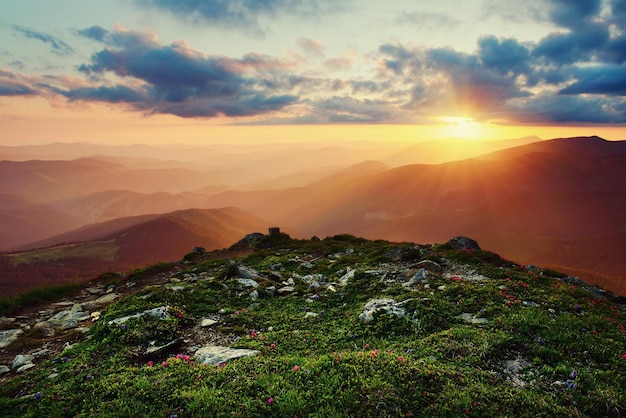 曇り空、自然な屋外旅行の背景にカラフルな鮮やかな夕日と素晴らしい山の風景。美容の世界。