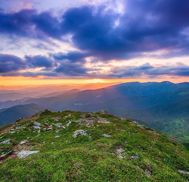 曇り空、自然な屋外旅行の背景にカラフルな鮮やかな夕日と素晴らしい山の風景。美容の世界。