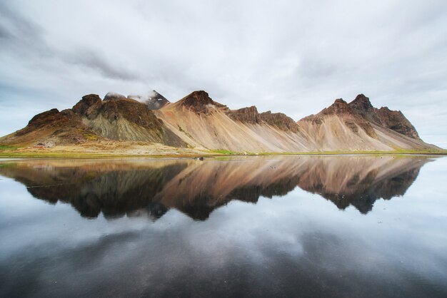 Amazing mountains reflected in the water at sunset. Stoksnes, Ic