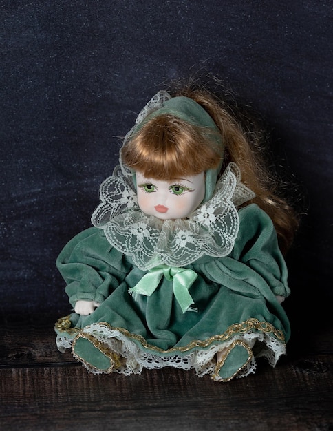 Photo amazing realistic vintage porcelain doll toy with green eyes the doll dressed in a green dress with lace