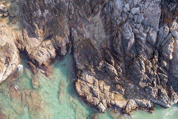 Amazing Sea aerial view Top down seashore nature background Beautiful Tropical beach with rocky mountains and turquoise clear water of Phuket Thailand ocean at sunny summer day Landscape background.