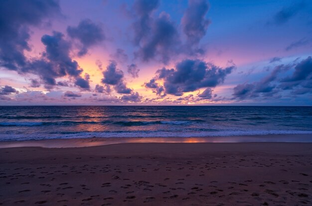 劇的な空の夕日や日の出と海に沈む夕日の雲と素晴らしい海の風景美しい自然のミニマリストの背景とテクスチャパノラマ自然ビュー風景暗い雲。