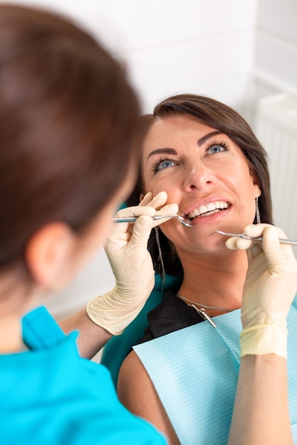 Amazing smile Top view of dentist examining his beautiful patient in dentist s office