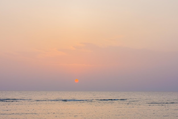 Amazing sunrise with orange warm sun and colorful sky at the sea