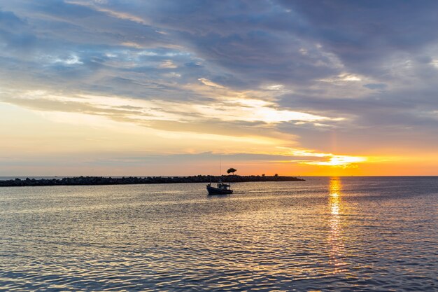 Amazing sunrise with silhouette image fishing boat 